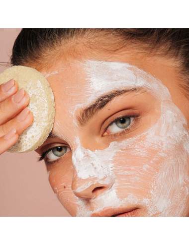 woman using a sponge to remove her makeup