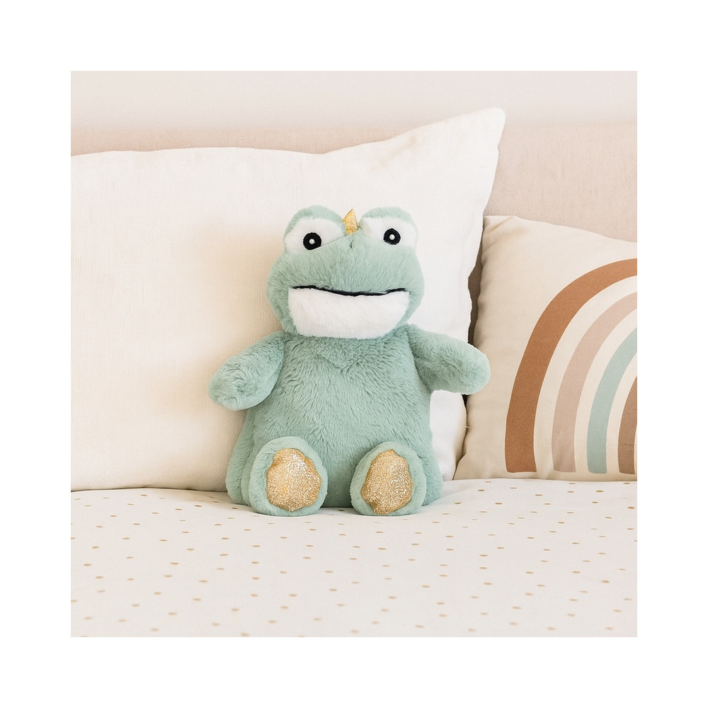 Doudou grenouille posé sur un lit