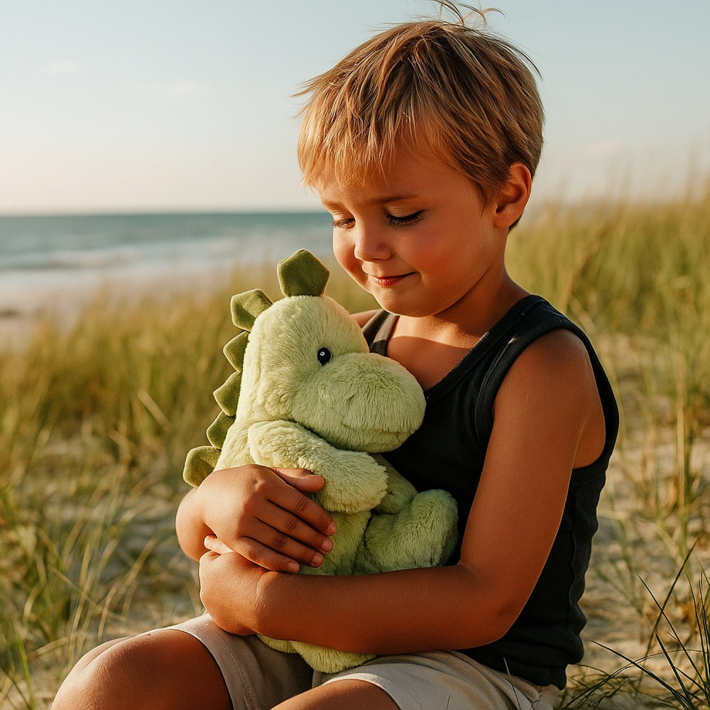 Bouillotte doudou dinosaure dans bras d'enfant